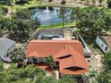 Aerial view of home with screened pool, overlooking a scenic pond with fountain at 15837 Hidden Lake Cir, Clermont, FL 34711