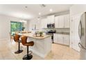 Modern kitchen features an island with granite countertops, stainless steel appliances, and eat-in dining area at 17112 Goldcrest Loop, Clermont, FL 34714