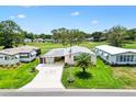 Aerial view of a cozy home featuring a well-manicured lawn and convenient golf course access at 1726 W Schwartz Blvd, Lady Lake, FL 32159