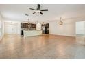 Bright, open-concept living space with tile floors, pendant lighting, and kitchen view at 185 Hamlet Loop, Davenport, FL 33837
