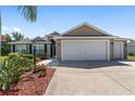 Attractive home with a spacious driveway, well-maintained lawn, and beautiful landscaping at 1910 Quiet Oak Ct, The Villages, FL 32162