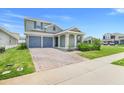 Charming home featuring a well-manicured lawn, an attached two-car garage, and decorative pillars on the front porch at 2025 Axel St, Minneola, FL 34715