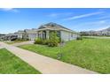 Lovely home with a well-maintained lawn, complemented by lush landscaping and a welcoming front facade at 2025 Axel St, Minneola, FL 34715