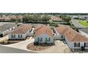 Aerial view of a well-maintained home with a brown roof, green shutters, and a landscaped yard in a residential neighborhood at 2050 Duval Ct, The Villages, FL 32162