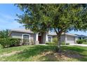 Charming single-story home with mature trees and landscaping. Two car garage and inviting front entrance at 211 Highland Meadows Ct, Davenport, FL 33837