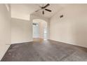 Bright living room featuring neutral walls, plush carpeting, ceiling fan, and an arched entrance at 211 Highland Meadows Ct, Davenport, FL 33837