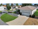 Aerial view of a charming home with a well-maintained lawn and driveway in a sunny neighborhood at 2111 Thornton Ter, The Villages, FL 32162