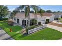 Aerial view of a charming home with a well-maintained lawn, landscaping, and driveway in a sunny neighborhood at 2111 Thornton Ter, The Villages, FL 32162