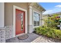 Inviting front entrance featuring a brick walkway, colorful plants, and a stylish door with decorative accents at 2666 Meadowedge Loop, St Cloud, FL 34772