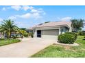 Charming home featuring a well-manicured lawn, lovely landscaping, and an attached two-car garage at 27018 Nature View St, Leesburg, FL 34748