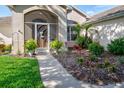 Close up of the front entrance featuring a charming screen door and fresh landscaping at 27146 Greenfly Orchid Ln, Leesburg, FL 34748