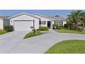 Inviting single-story home with a well-maintained lawn and an attached garage at 2785 Privada Dr, The Villages, FL 32162