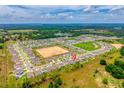 Expansive aerial view of a vibrant community with numerous homes, green spaces, and picturesque ponds at 33960 Sky Blossom Cir, Leesburg, FL 34788
