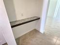 Hallway area with a shelf, tiled floor, and bright white walls at 358 Switchgrass Loop, Minneola, FL 34715