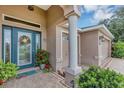Charming front entrance features a decorative glass door, sidelight windows, and colorful landscaping at 3809 Arlington Ridge Blvd, Leesburg, FL 34748
