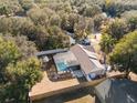 Aerial view of a private backyard with a screened-in pool, surrounded by mature trees at 40140 Palm St, Lady Lake, FL 32159