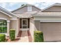 Close up front exterior view of home featuring a screened entryway, brick paver walkway and two-car garage at 4083 Capland Ave, Clermont, FL 34711