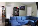 Spacious living room with plush blue sectional, wood-look flooring, and neutral wall color at 41 Dogwood Loop, Ocala, FL 34472