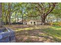 The backyard featuring a spacious yard surrounded by mature trees, partially fenced for privacy at 43 Almond Pass Dr, Ocala, FL 34472