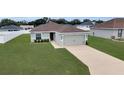Well-maintained single-Gathering home featuring a tidy lawn and neutral-colored exterior at 5547 Se 91St Pl, Ocala, FL 34480