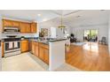 A bright open floor plan with stainless steel appliances, wood cabinets, and tile floors at 654 Fayette Ct, The Villages, FL 32162