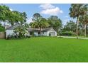 Well-maintained home with manicured lawn and mature landscaping features palm trees at 717 Southeast 46Th Ct, Ocala, FL 34471