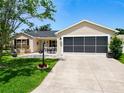 Well-maintained home with a front patio, screen garage, lush lawn, and attractive landscaping at 750 Eden Pl, The Villages, FL 32162