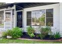 Inviting front porch features a small garden and a view into the living area at 841 S Michigan Ave, Groveland, FL 34736