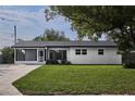 Well-maintained single-story home features a lush green lawn and a screened-in front porch at 841 S Michigan Ave, Groveland, FL 34736