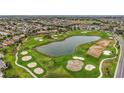 Panoramic aerial view showcasing the golf course, lake, and residential neighborhood at 946 Isle Of Palms Path, The Villages, FL 32162