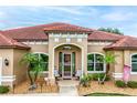 Close-up of a beautiful entryway showcasing arched windows, decorative plants, and seating at 10240 Kabana Blvd, Clermont, FL 34711