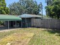 View of a backyard with a carport and wooden fence at 1095 Golden Isle Dr, Mount Dora, FL 32757