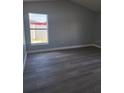 This bedroom features updated flooring, neutral-colored walls, and a bright window at 112 Arlington Ct, Haines City, FL 33844