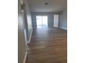 A spacious living room with vinyl floors, neutral-colored walls, and sliding glass door to the patio at 112 Arlington Ct, Haines City, FL 33844
