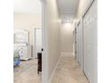 Neutral hallway with tiled floor leading to multiple rooms, with several closet doors for ample storage at 11215 Se 172Nd Place, Summerfield, FL 34491
