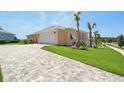 Peach-colored home featuring a paved driveway and an attached two-car garage at 1127 Fiesta Key Cir, Lady Lake, FL 32159