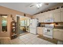 Bright kitchen featuring white appliances, tile floors, and a pass-through to the sunroom at 11495 Se 71St Terrace Rd, Morriston, FL 32668