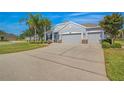 Charming single-story home with a well-manicured lawn, mature trees, three-car garage, and a long driveway at 11601 Thacker Dr, Clermont, FL 34711