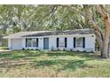 Charming single-story home with a well-maintained front yard, driveway leading to attached garage and mature landscaping at 1228 Padgett Cir, Lady Lake, FL 32159