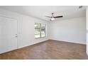 Bright living room featuring wood-look tile flooring, ceiling fan, and a window providing ample natural light at 1228 Padgett Cir, Lady Lake, FL 32159