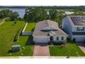New construction single Gathering home with a brick driveway and beautifully manicured lawn at 124 Juno Dr, Groveland, FL 34736