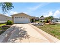Charming single-story home featuring a well-maintained lawn, landscaped flower beds, and a two-car garage at 1282 Fort Lawn Loop, The Villages, FL 32162