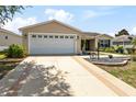Charming single-story home featuring a well-maintained lawn, landscaped flower beds, and a two-car garage at 1282 Fort Lawn Loop, The Villages, FL 32162