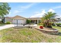 Charming single-story home featuring a well-maintained lawn, landscaped flower beds, and a two-car garage at 1282 Fort Lawn Loop, The Villages, FL 32162