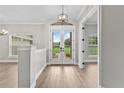 Bright foyer with wood flooring and French doors leading to a landscaped backyard at 12913 County Road 104B, Oxford, FL 34484