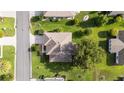 Aerial view of a well-maintained home featuring a lush green yard and mature trees at 13643 Se 89Th Ct, Summerfield, FL 34491