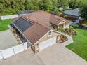 Elevated view displaying the house with solar panels, driveway, backyard, and verdant surroundings at 15664 Se 97Th Ave, Summerfield, FL 34491