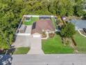 Expansive aerial shot showcasing the home's layout, fenced yard, pool, and surrounding greenery at 15664 Se 97Th Ave, Summerfield, FL 34491