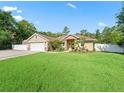 Inviting single-Gathering home with a lush green lawn and complemented by mature landscaping at 15664 Se 97Th Ave, Summerfield, FL 34491