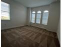 Bright bedroom featuring carpet floors, large windows, and ample natural light at 1849 Sunshine Peak Dr, Minneola, FL 34715